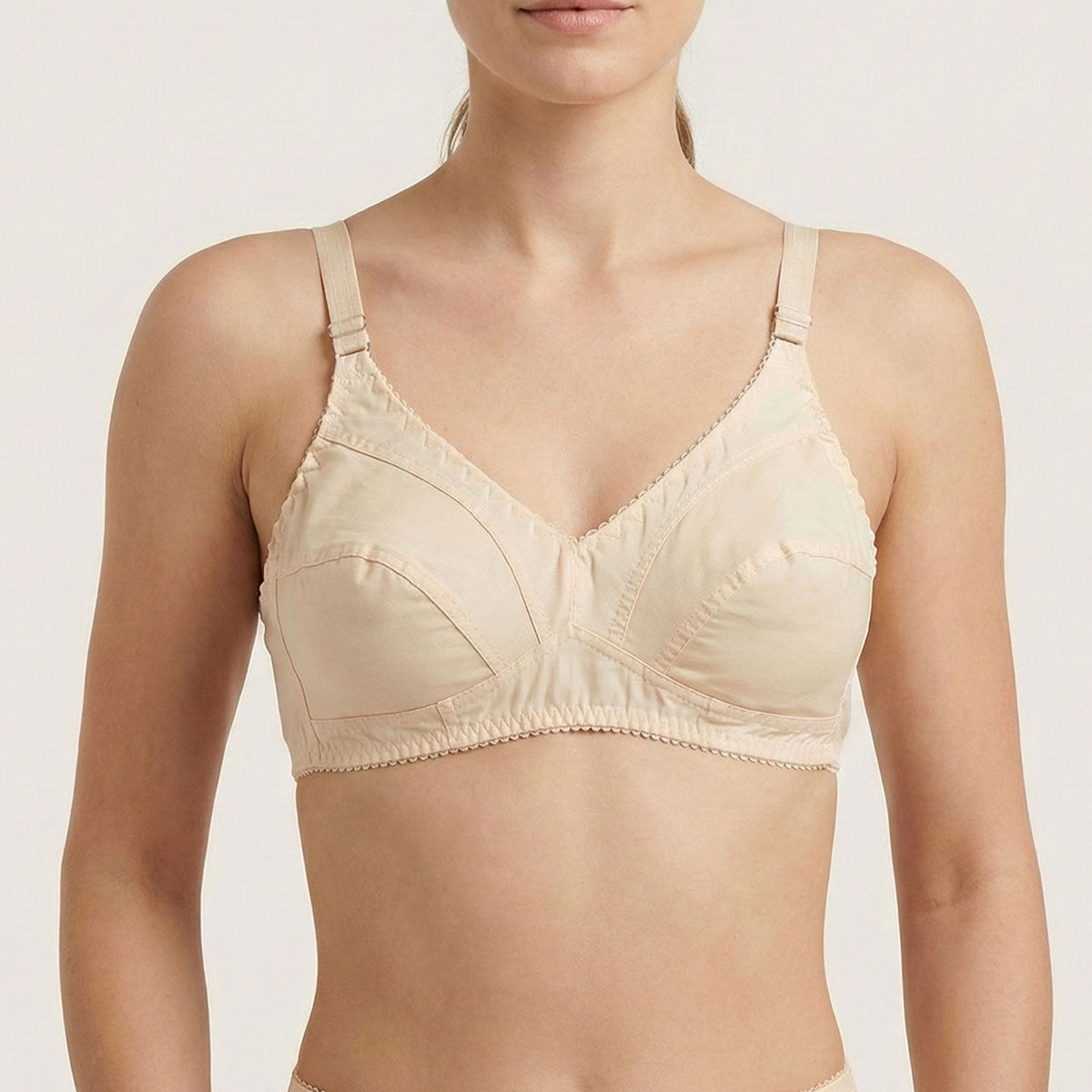 Beige bra worn by a model on a plain background