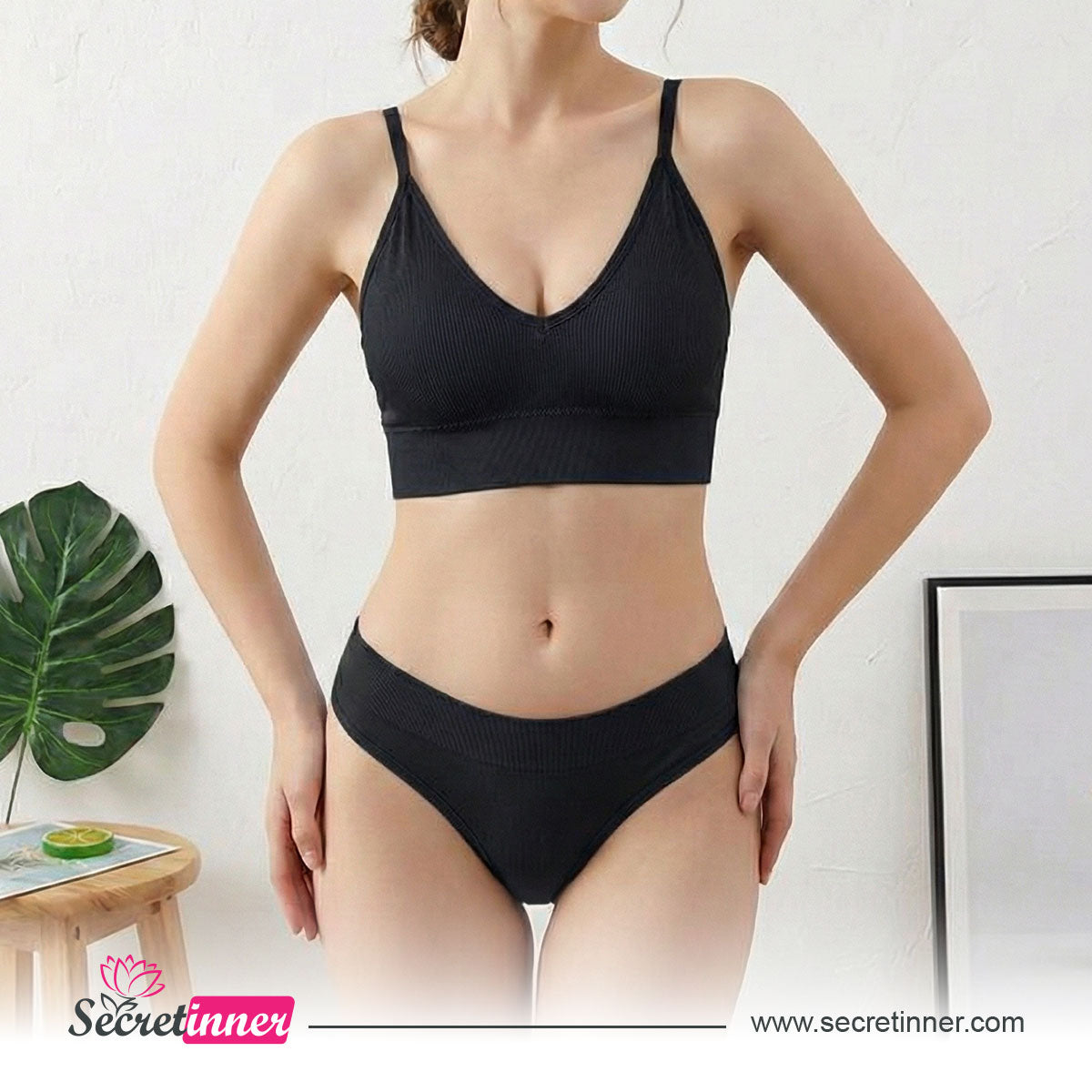 Woman wearing a black bra and panties set with a white background, featuring the Secret Inner brand.