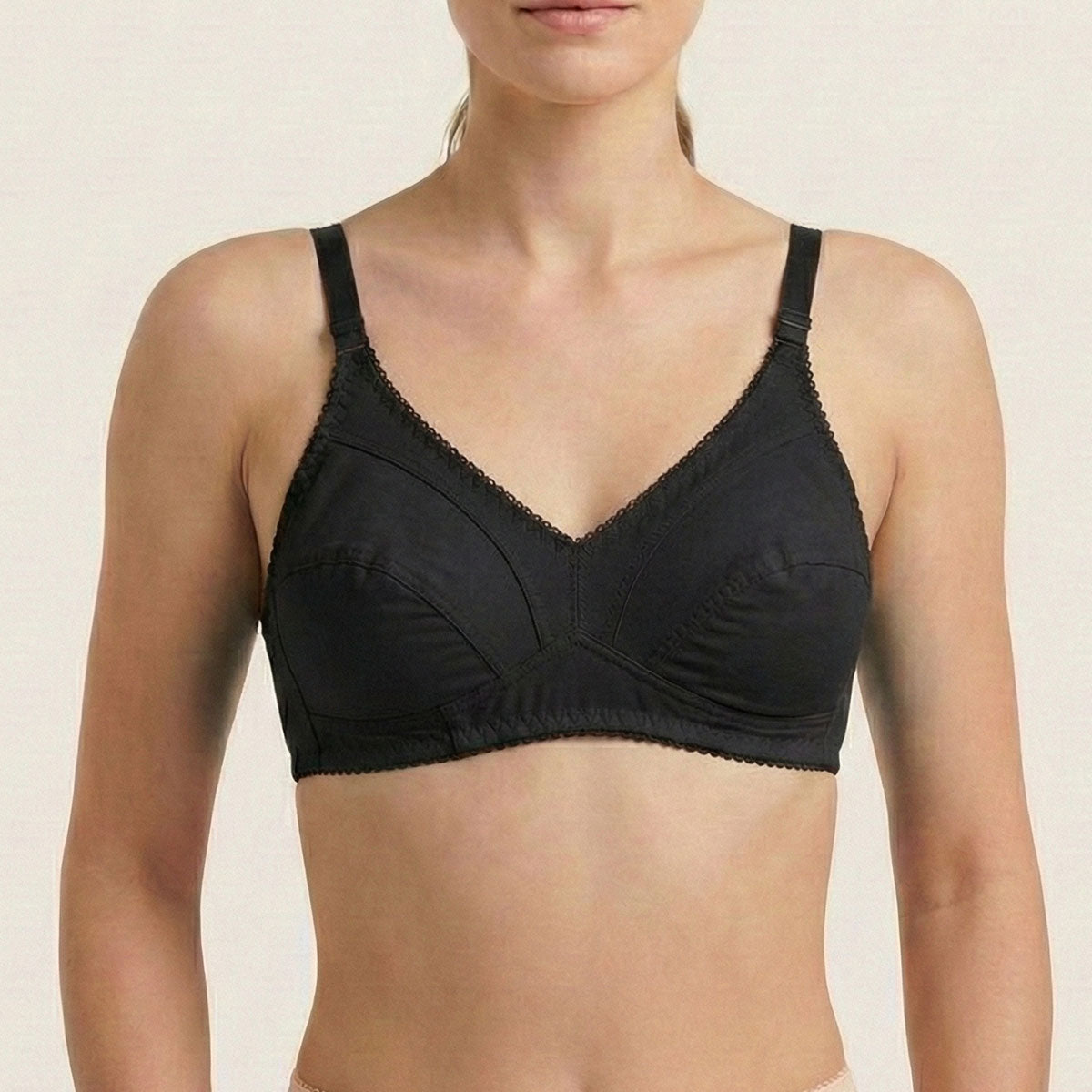 Black bra worn by a model on a beige background