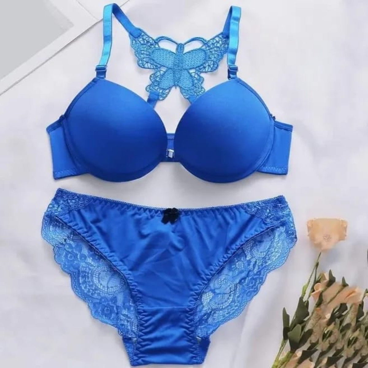 Blue bra and panties set with lace details on a white background