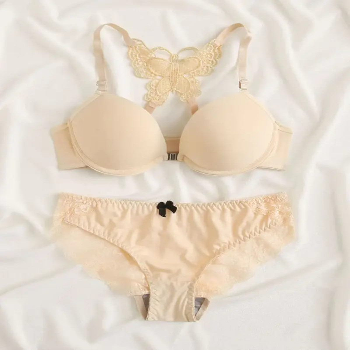 Beige bra and panties set on a white fabric background
