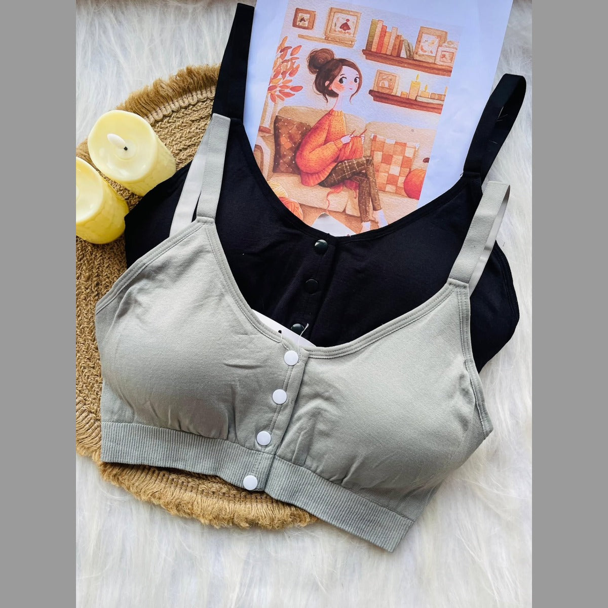 Gray bra with buttons on a white surface with candles and a magazine in the background