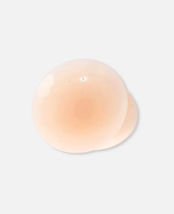 Round, peach-colored object on a light gray background