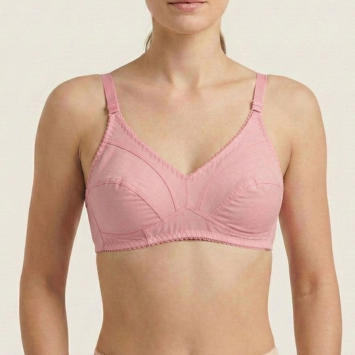 Pink bra worn by a person on a beige background