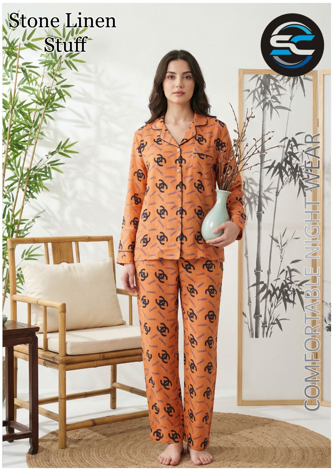 Woman wearing an orange pajama set with a black pattern in a room with a chair and plants.