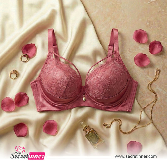 Pink bra on a beige fabric background with rose petals and jewelry, Secretinner brand visible.